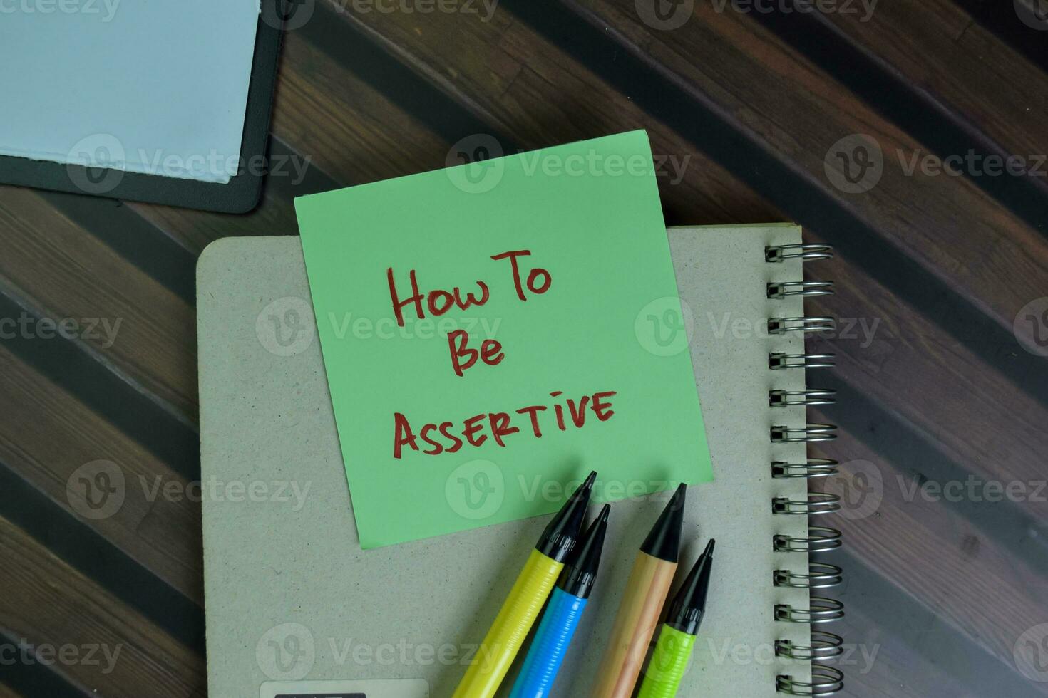 How to be Assertive write on sticky notes isolated on Wooden Table. photo