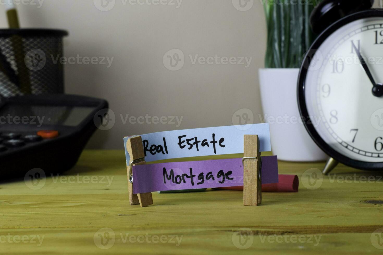 Real Estate and Mortgage. Handwriting on sticky notes in clothes pegs on wooden office desk photo