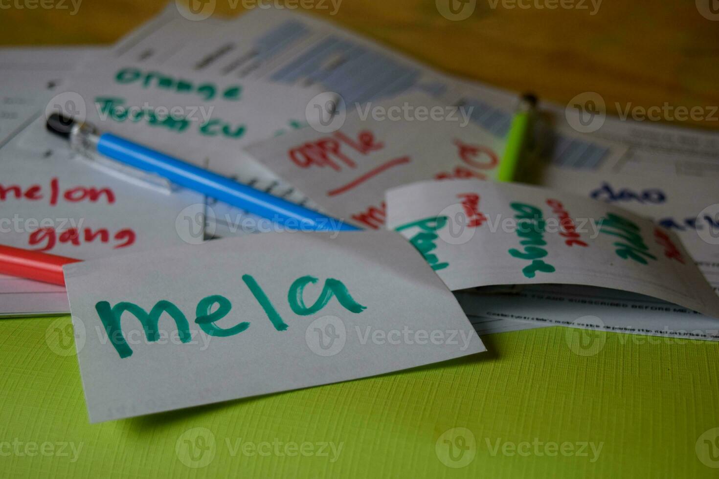 Mela write on a sticky note its mean apple isolated on Office Desk. Learning Italian Language concept photo