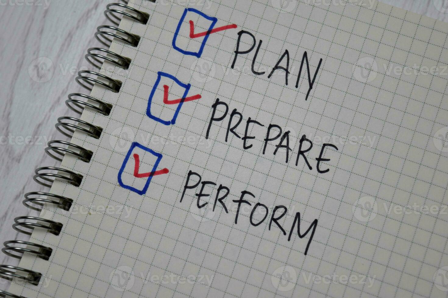 Plan, Prepare, Perform write on a book isolated on wooden table. photo
