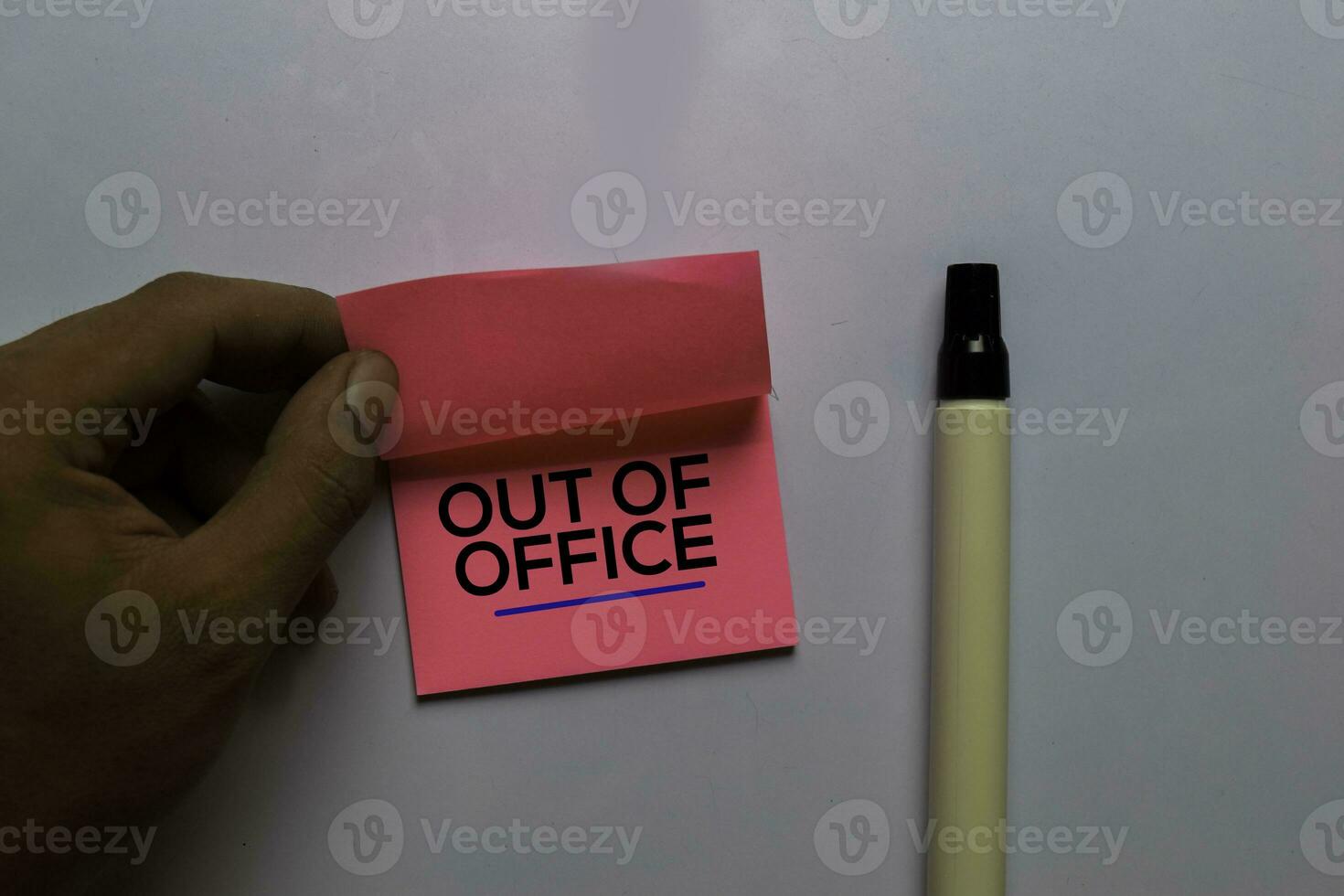 Out Of Office write on sticky notes. Isolated on white table background photo