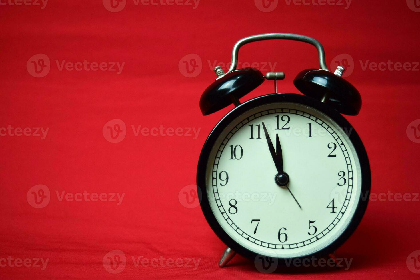 Clock ticking to 12 o'clock on the red background photo