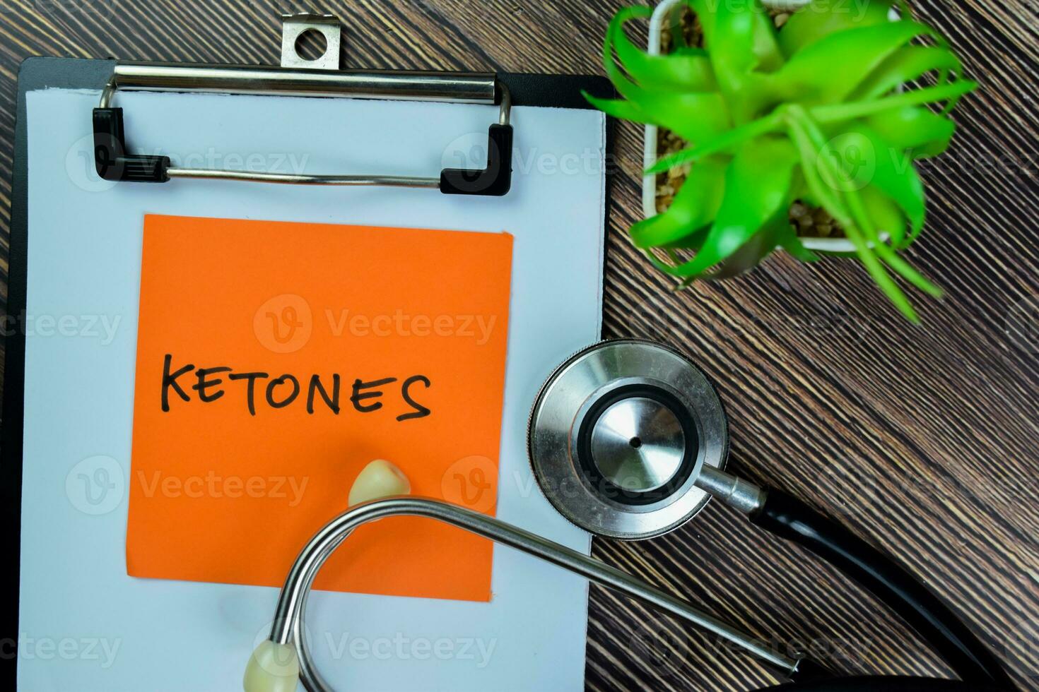 Concept of Ketones write on sticky notes with stethoscope isolated on Wooden Table. photo