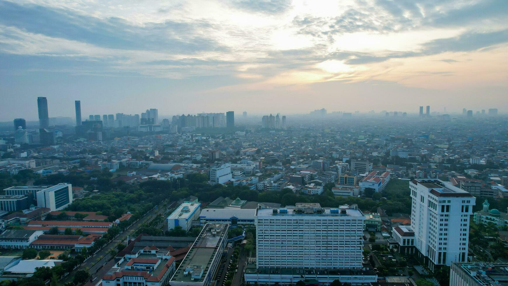 Aerial view of office buildings in Jakarta central business district and noise cloud when sunrise. Jakarta, Indonesia, May 6, 2022 photo