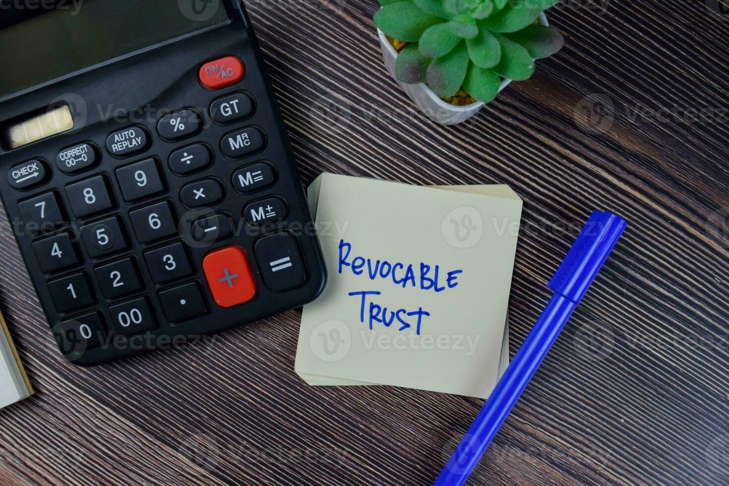 Revocable Trust write on sticky notes isolated on Wooden Table. photo