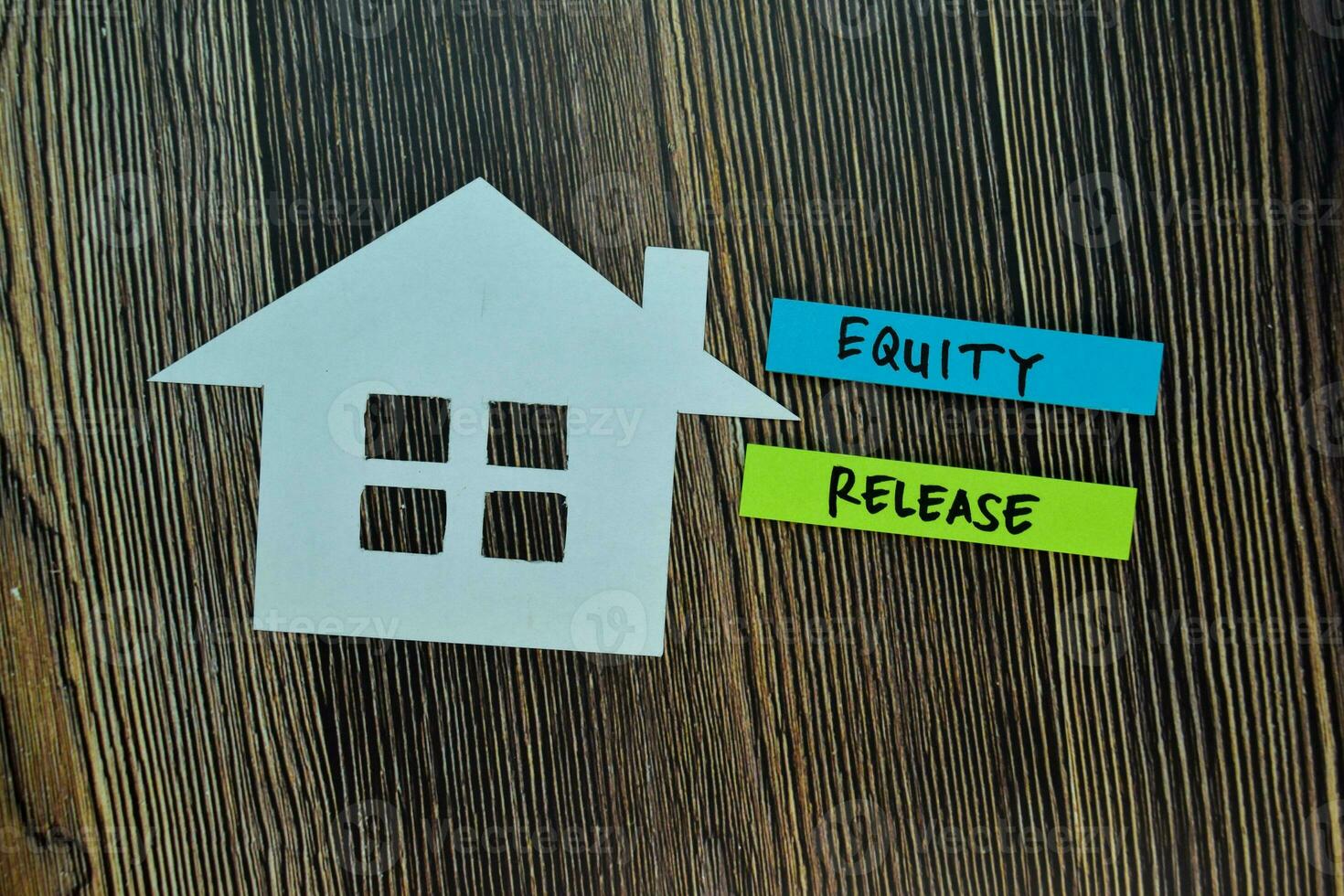 Equity Release write on sticky note and house made from paper isolated on Office Desk. Retirement concept photo