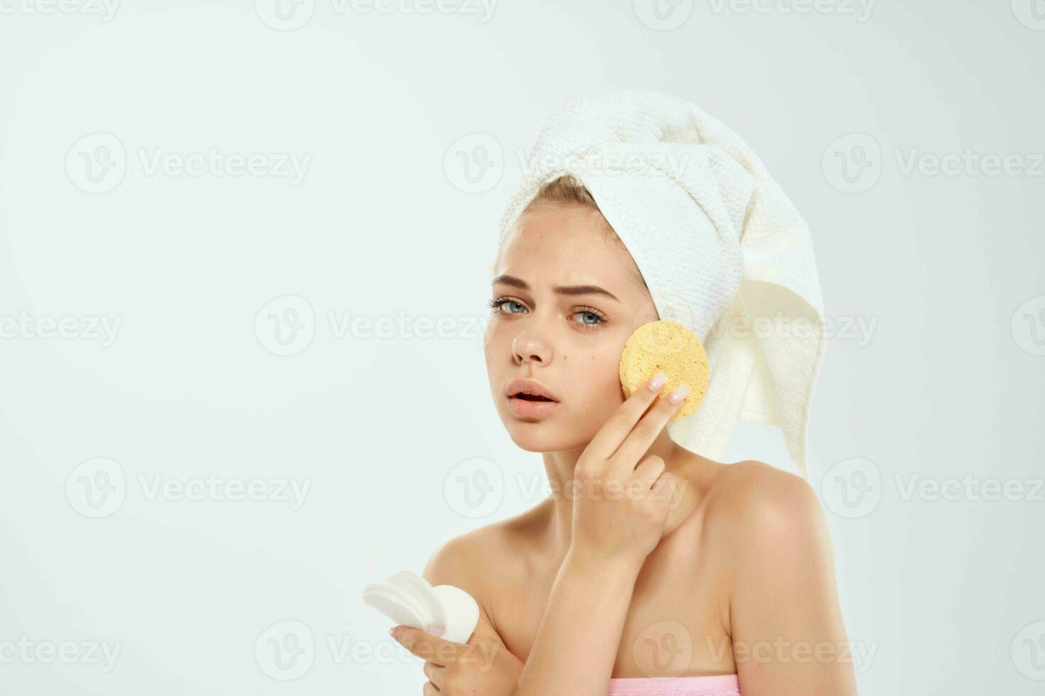 pretty woman with bare shoulders sponge clean skin health light background photo