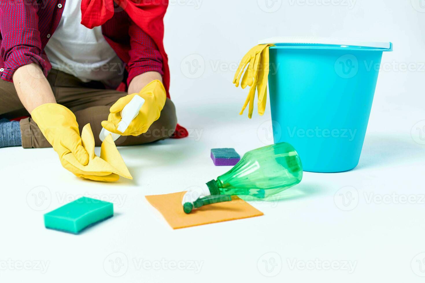 A man in a red raincoat sitting at home washing the floors providing services detergent accessories photo