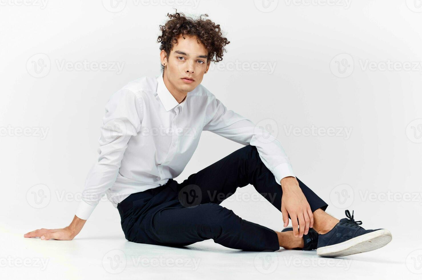 guy in a white shirt sitting on the floor curly hair fashion photo