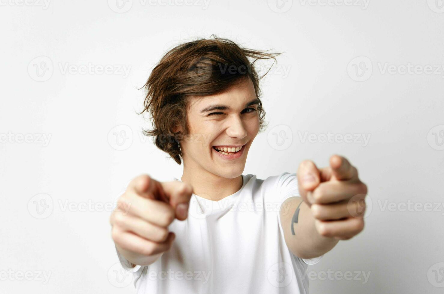 cute guy in white t-shirt tousled hair emotions posing photo