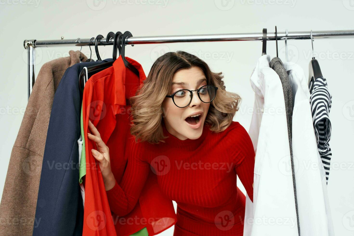 pretty woman in a red jacket near the wardrobe retail light background photo