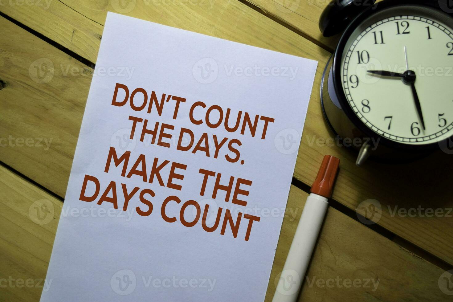 Don't Count The Days. Make The Days Count text on the paper isolated on table background photo