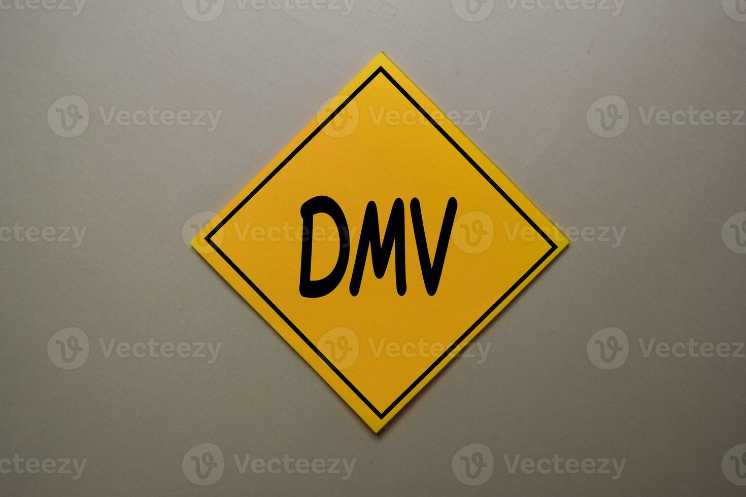 DMV write on a sticky note isolated on office desk. photo