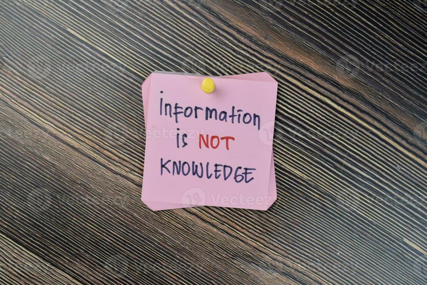 Concept of Information is not knowledge write on sticky notes isolated on Wooden Table. photo