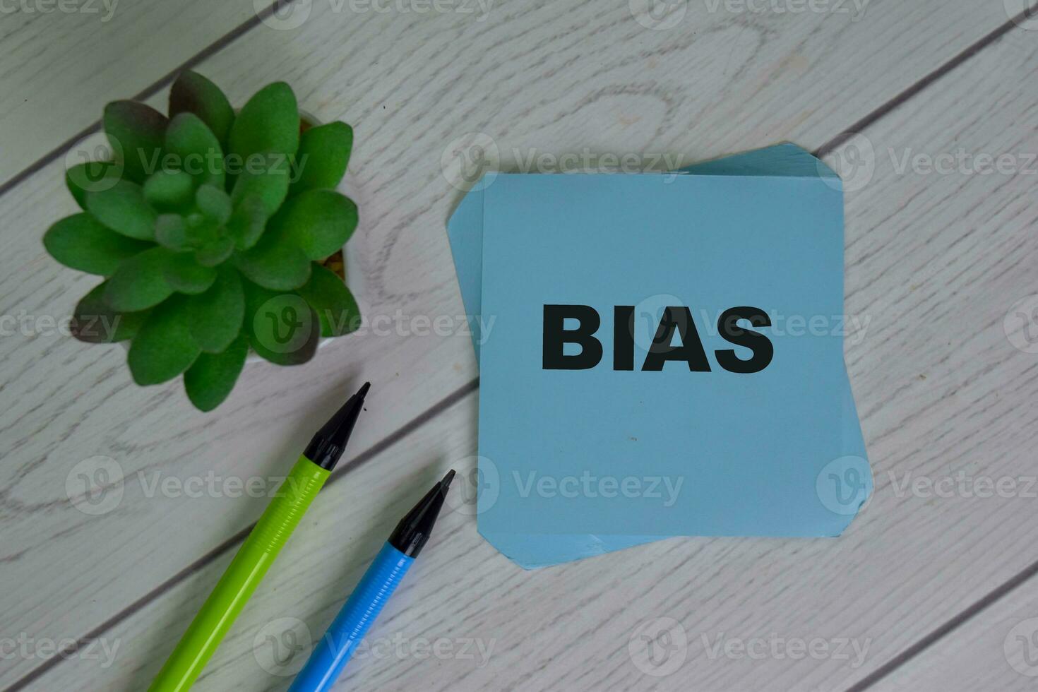Bias write on sticky notes isolated on Wooden Table. photo