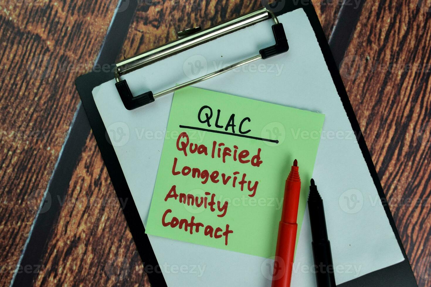 QLAC - Qualified Longevity Annuity Contract write on sticky notes isolated on Wooden Table. photo