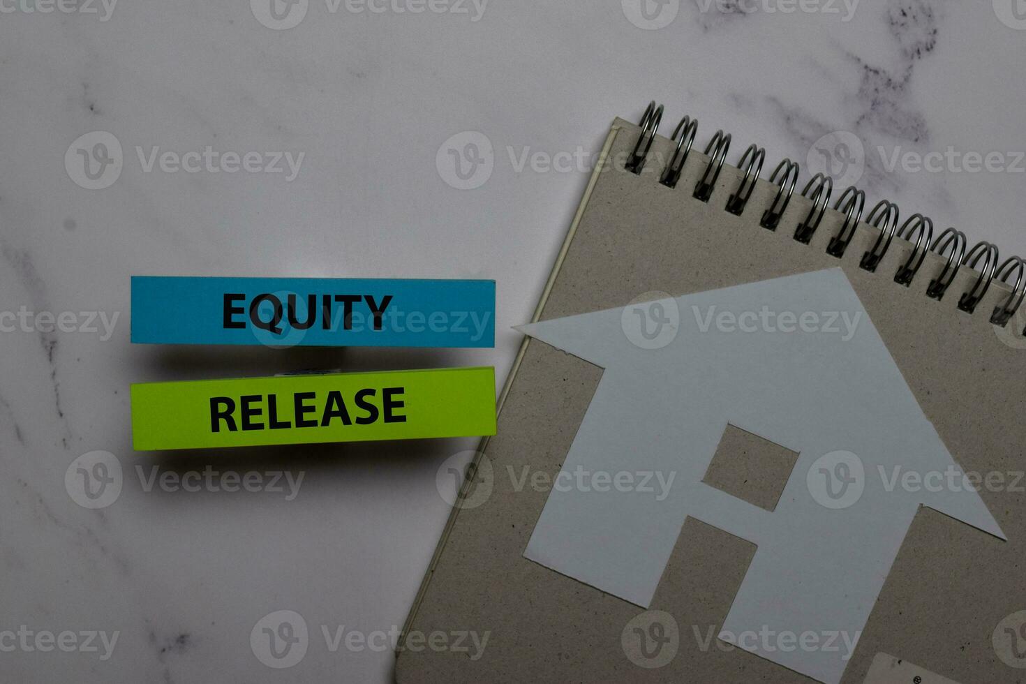Equity Release write on sticky note and house made from paper isolated on Office Desk. Retirement concept photo