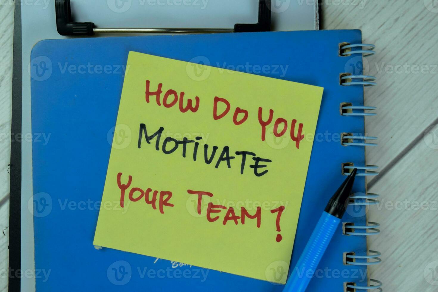 Concept of How Do You Motivate Your Team write on sticky notes isolated on Wooden Table. photo