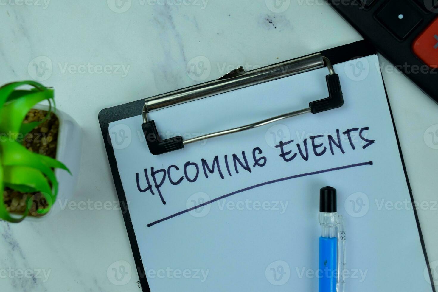 Concept of Upcoming Events write on a paperwork isolated on Wooden Table. photo