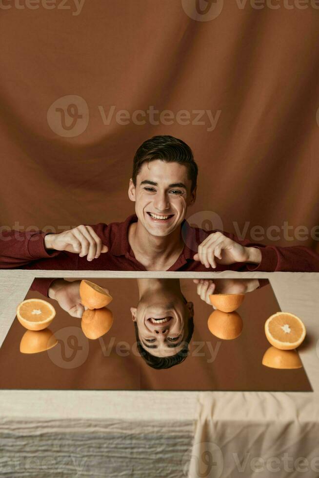 Man at the table with oranges and fabric background cropped view photo