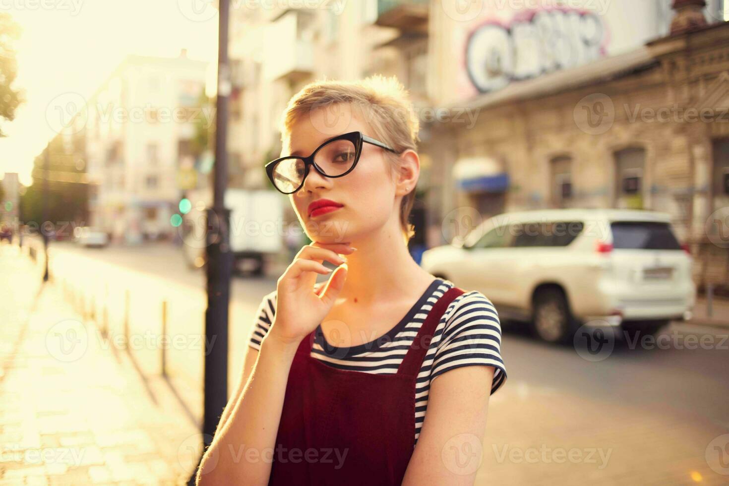 short haired woman wearing glasses outdoors walking posing photo