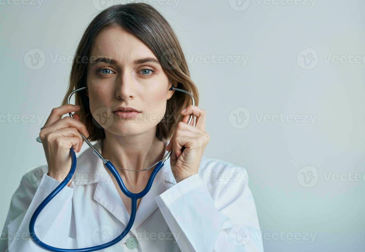 Woman with professional stethoscope Doctor in medical gown in bright room photo