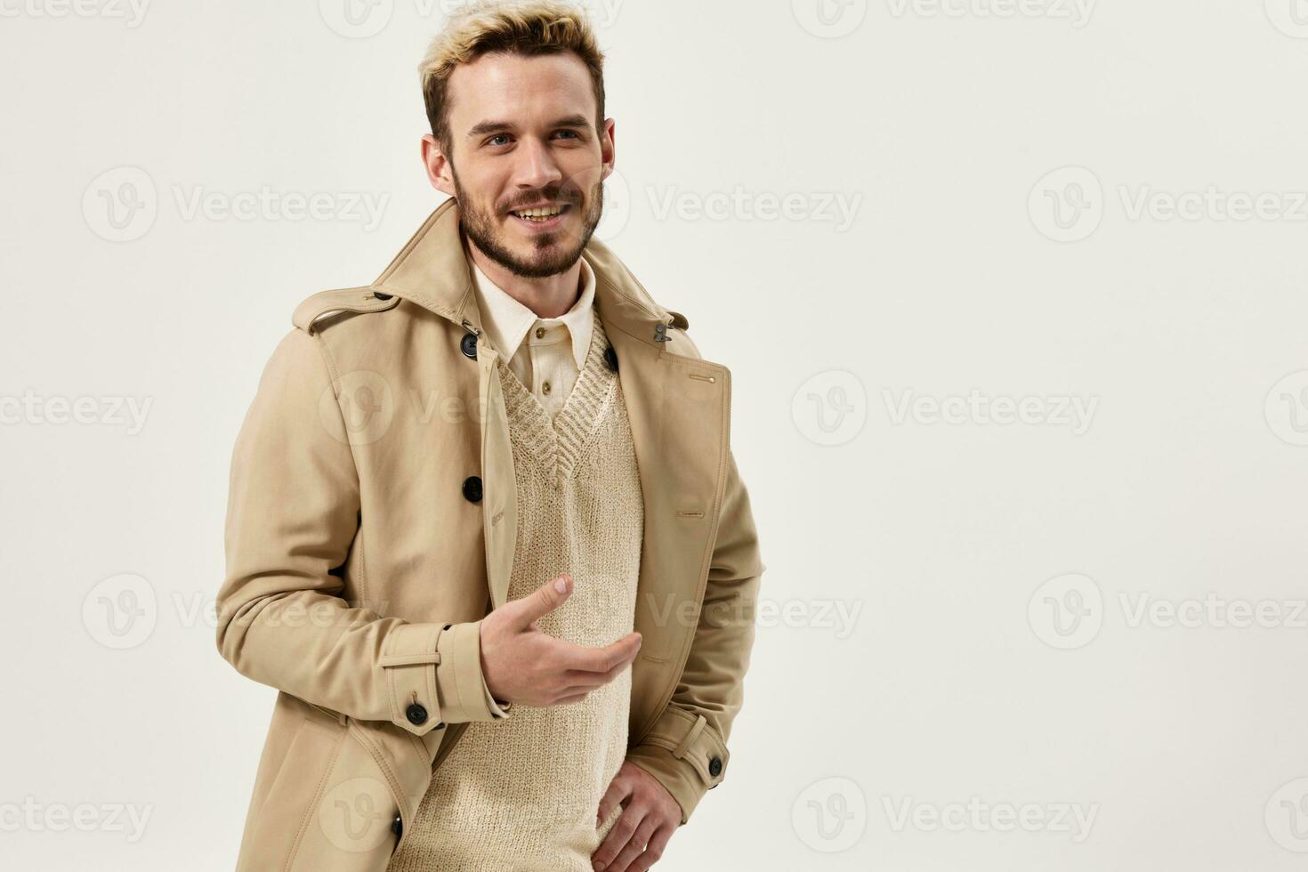man throws up his hands beige coat autumn style studio model photo