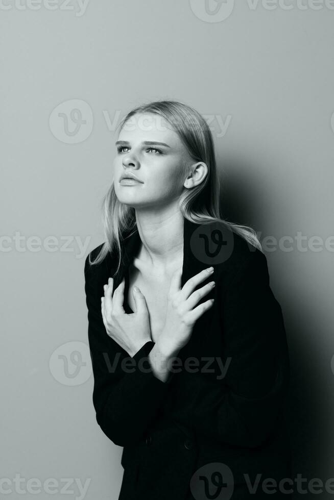 A stylish professional model crosses her arms on her chest and holds a jacket while posing in the studio. Fashionable stylish photo. Concept for clothing brands photo