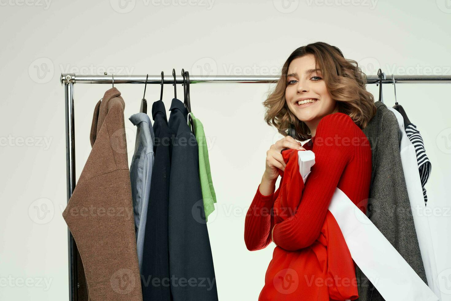 beautiful woman in a red jacket near the wardrobe isolated background photo