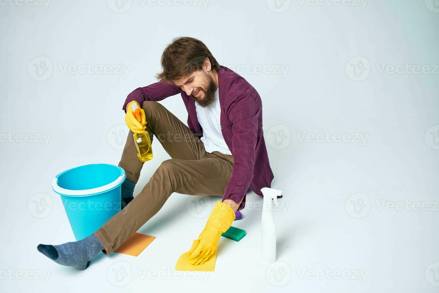 Cleaner sits on the floor with a bucket of homework service room interior photo