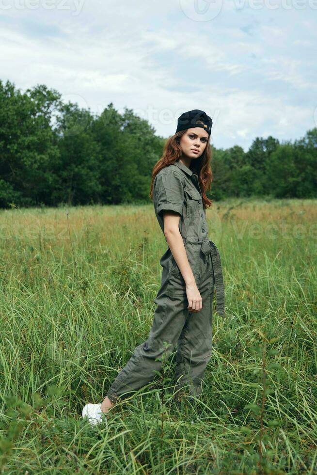 woman outdoors Tall grass in fresh air in green overalls photo