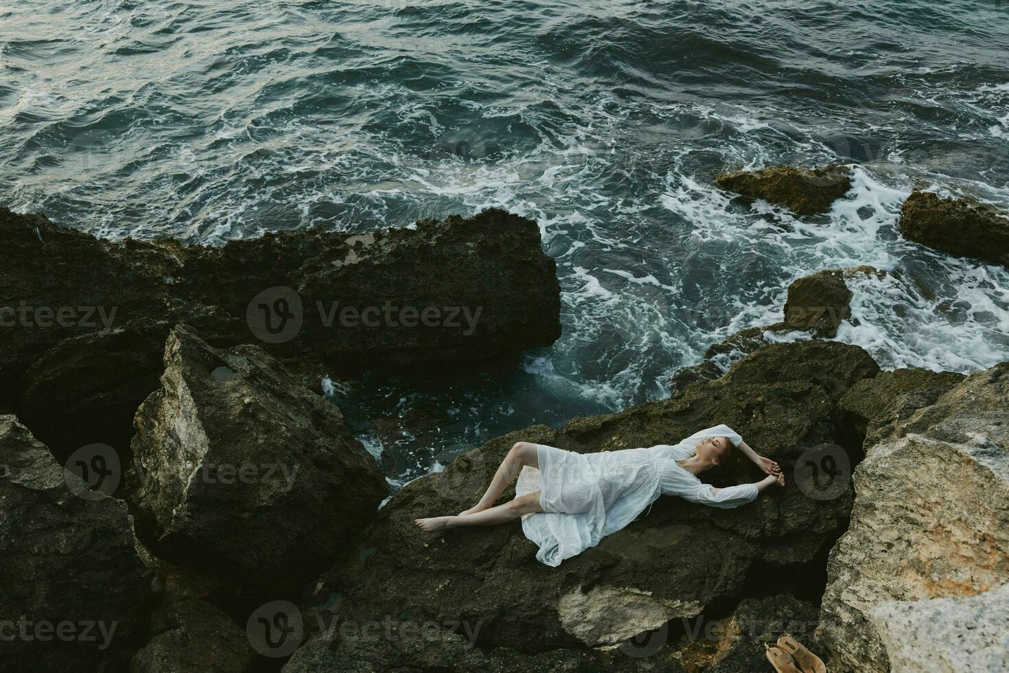 woman in a white dress lying on a stone in a white dress nature landscape photo