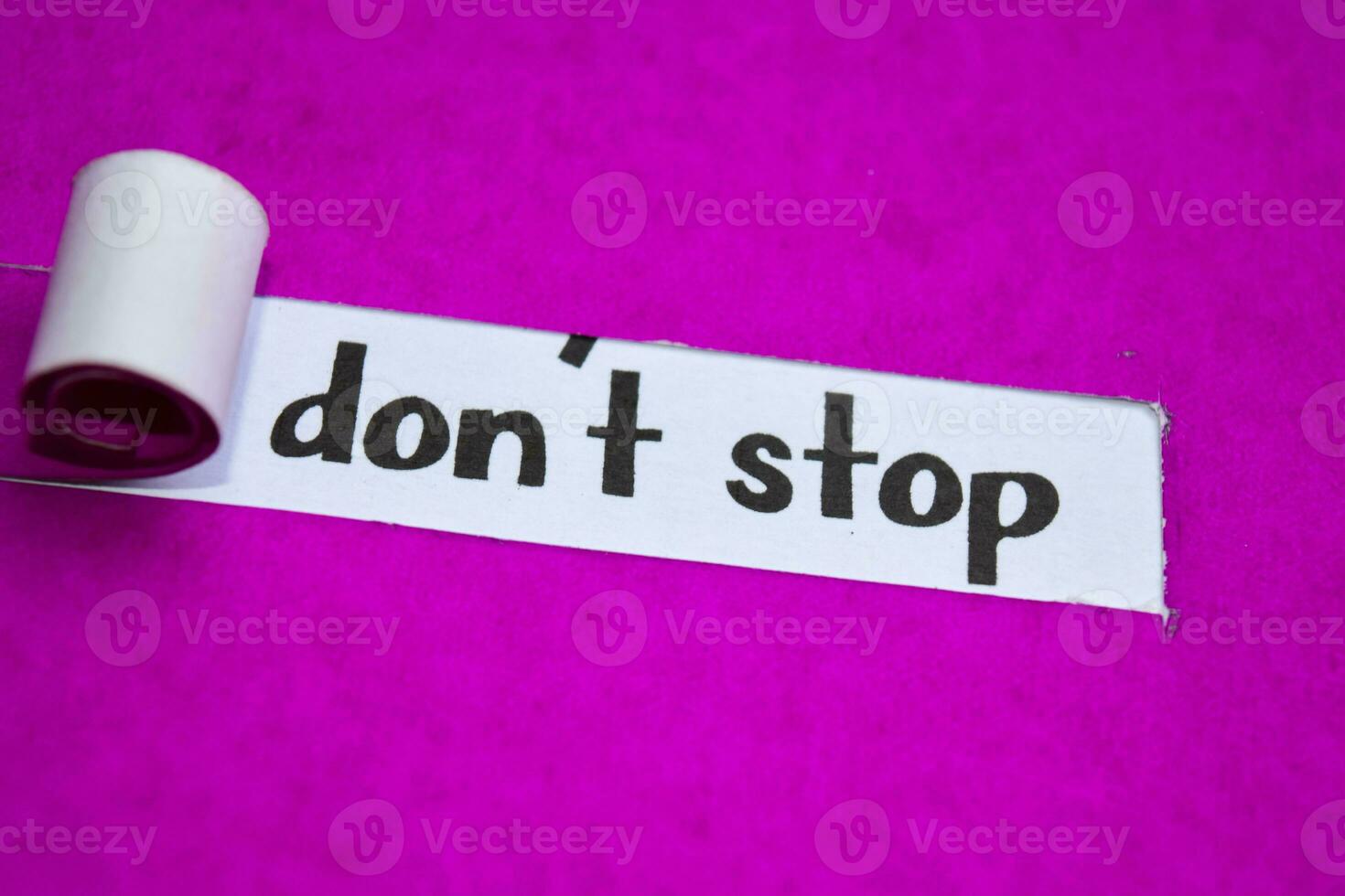 Don't Stop text, Inspiration, Motivation and business concept on purple torn paper photo