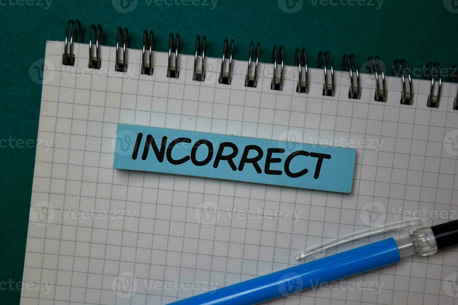 Incorrect write on a sticky note isolated on green background. photo