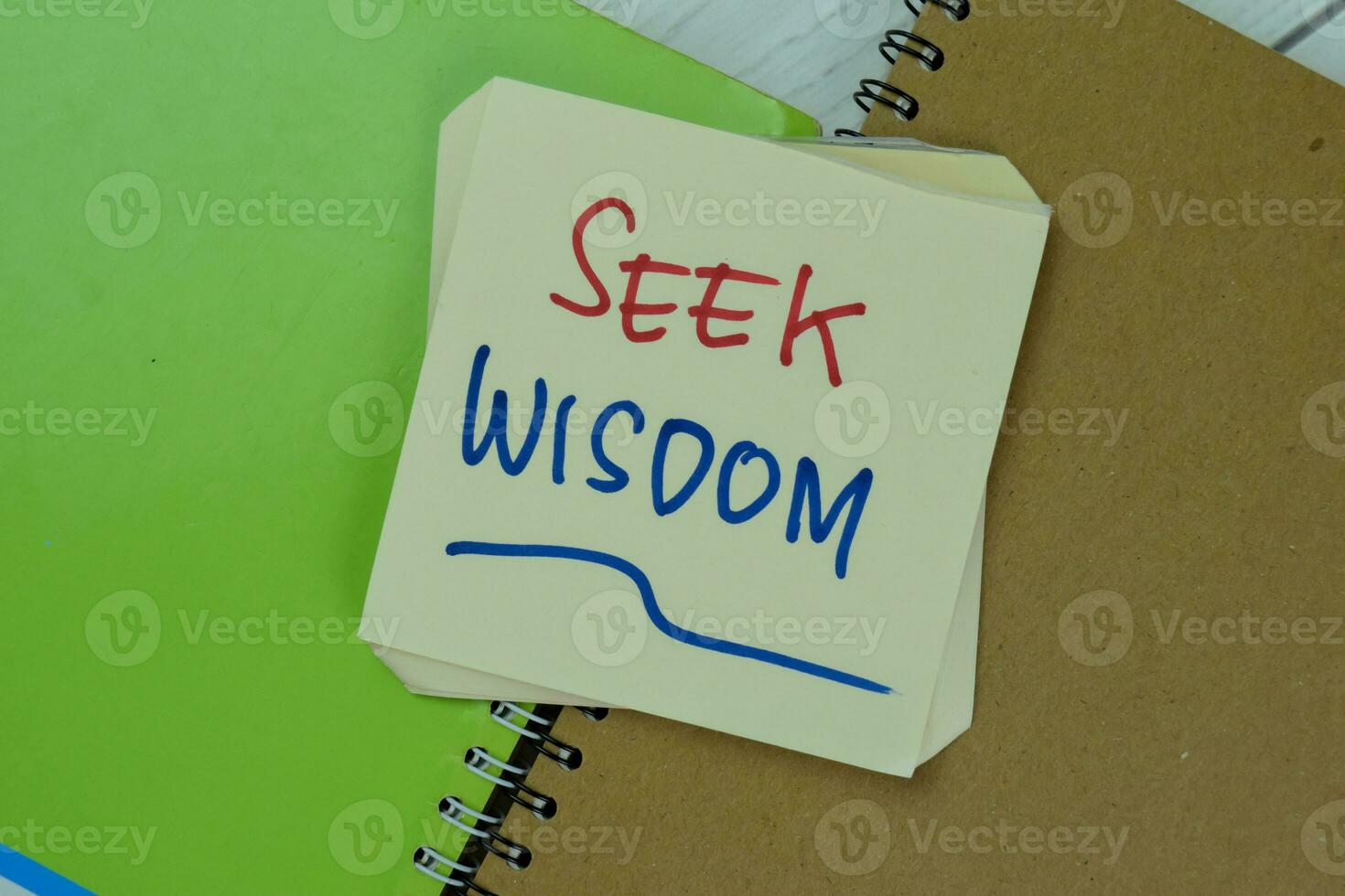 Concept of Seek Wisdom write on sticky notes isolated on Wooden Table. photo