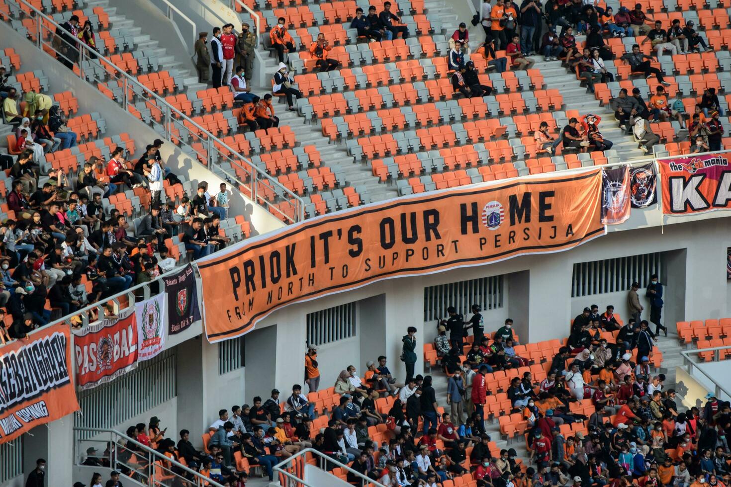 Crowds on Group of fans on the stadium Jakarta International Stadium. Selective focus on banner. Jakarta, Indonesia, August 1, 2022 photo