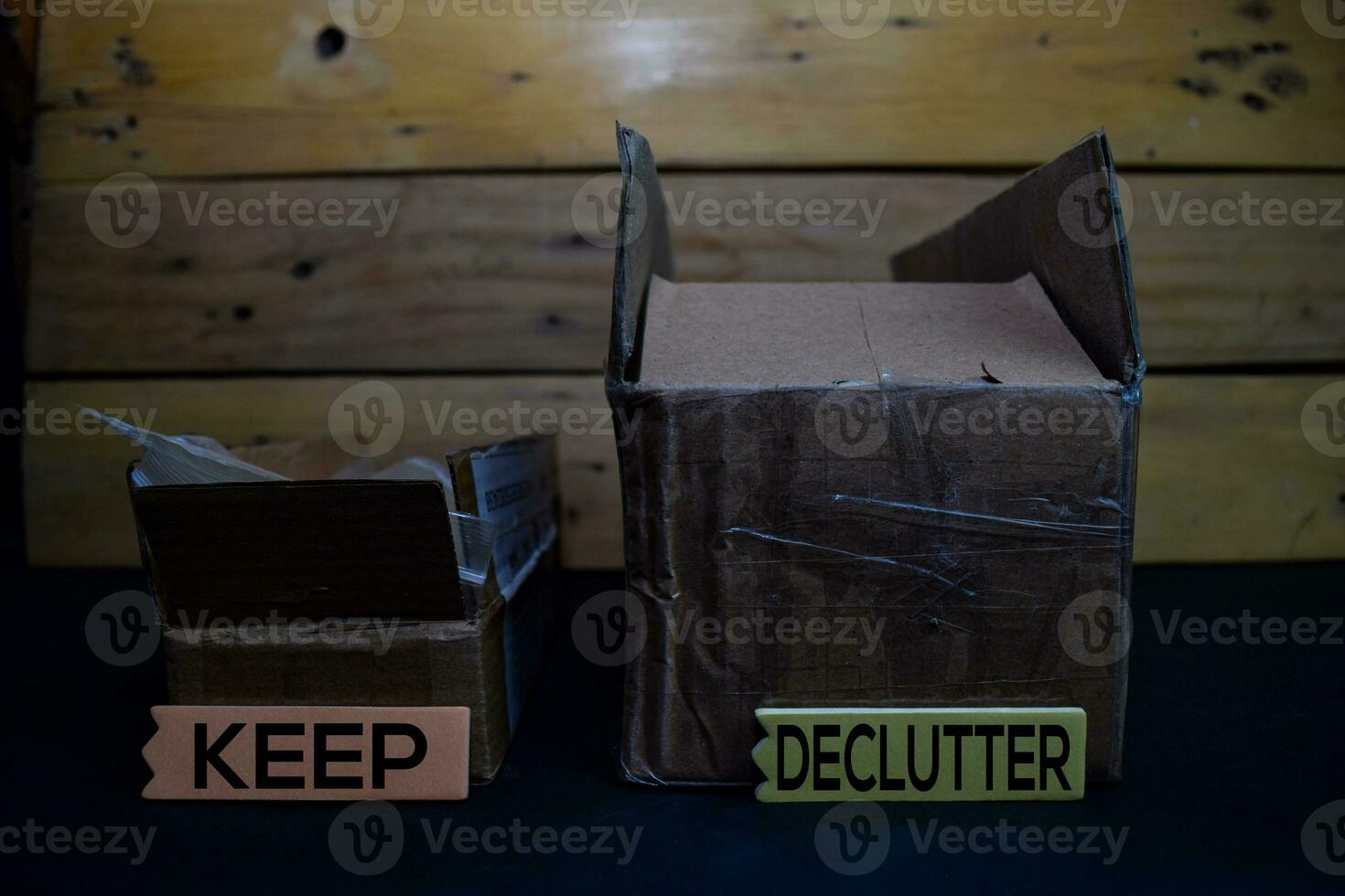 Keep and Declutter write on a sticky note between storage box isolated on wooden background. photo