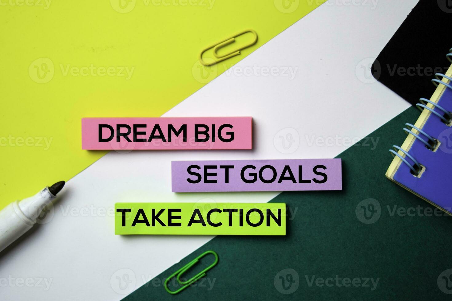 Dream Big. Set Goals. Take Action text on sticky notes with office desk concept photo