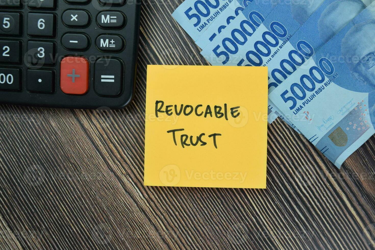 Concept of Revocable Trust write on sticky notes isolated on Wooden Table. photo