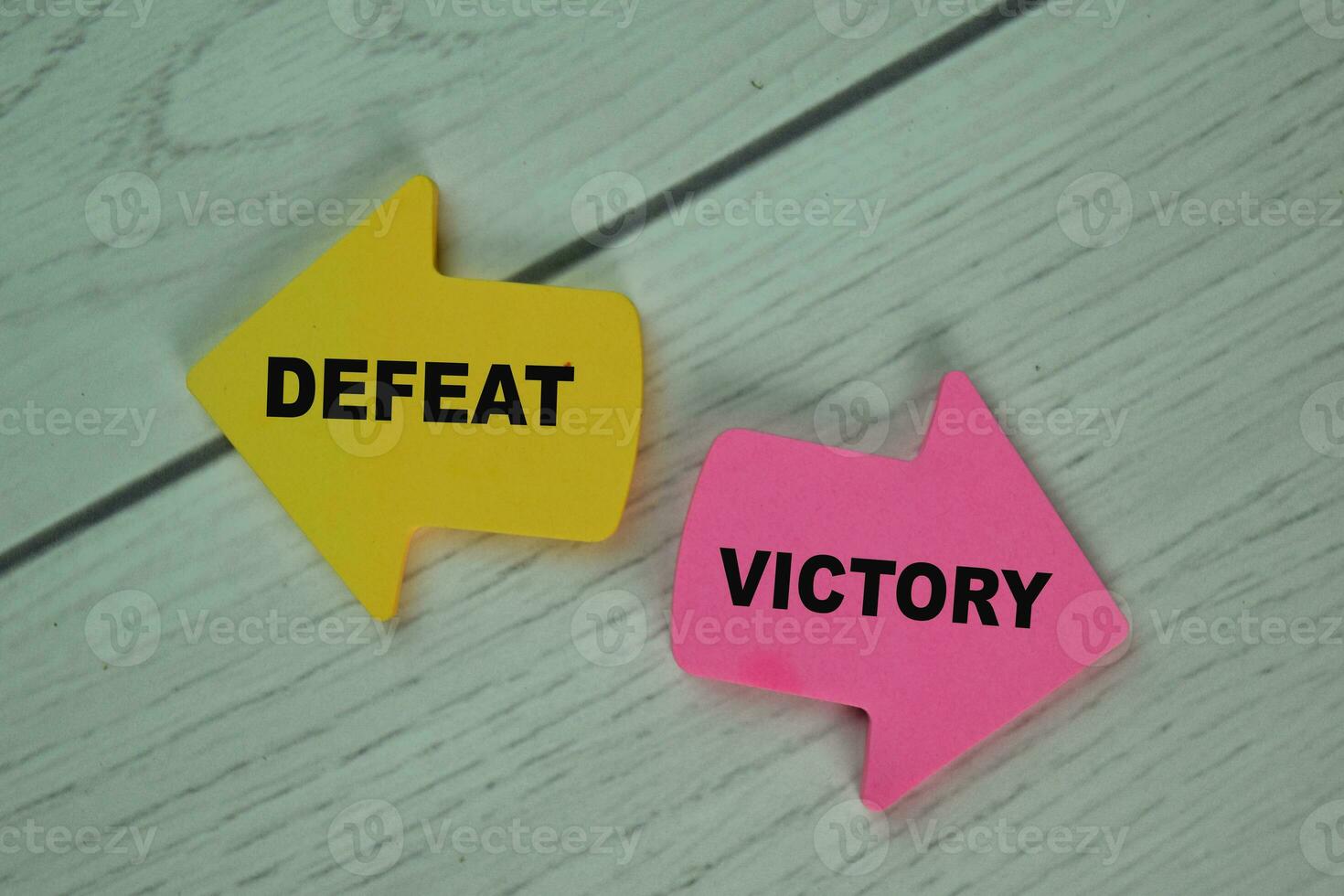 Defeat or Victory write on sticky notes isolated on Wooden Table. photo
