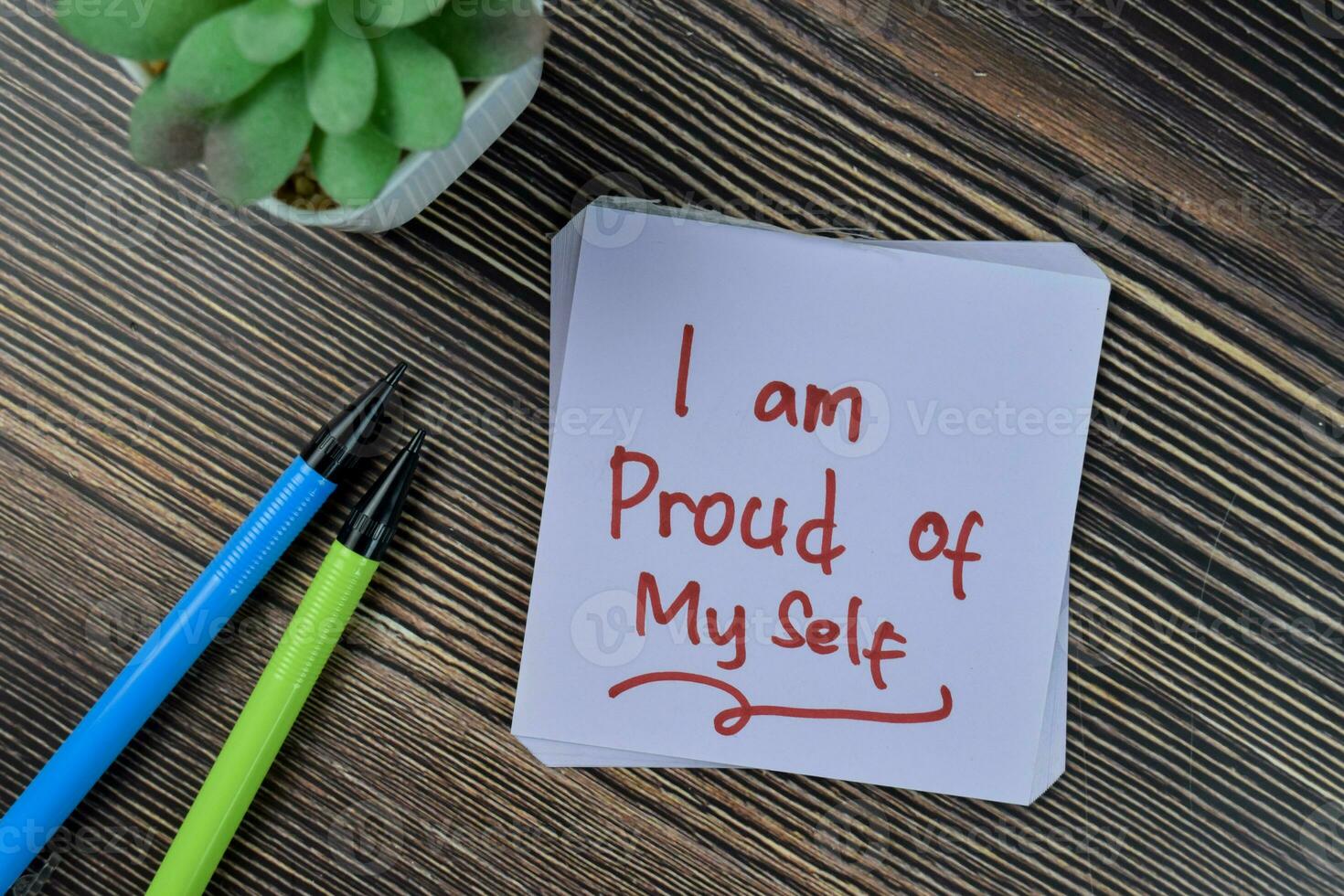 Concept of I am proud of my self write on sticky notes isolated on Wooden Table. photo