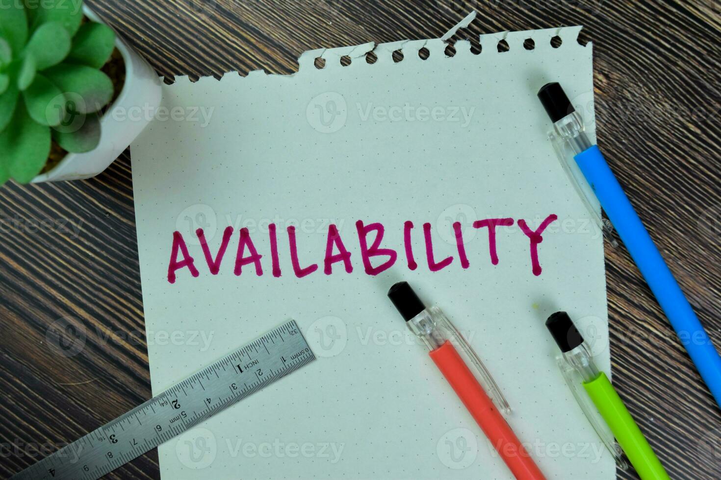 Concept of Availability write on sticky notes isolated on Wooden Table. photo