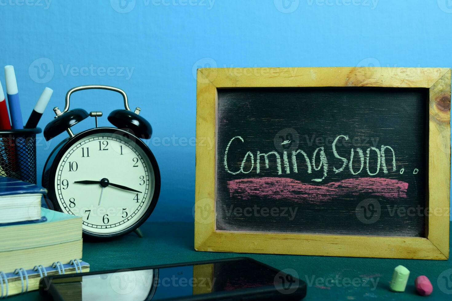Coming Soon Planning on Background of Working Table with Office Supplies. Business Concept Planning on Blue Background photo