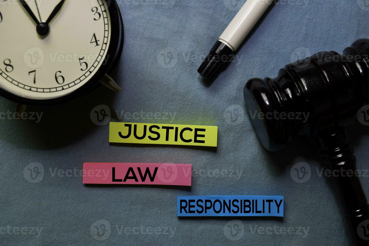Justice, Law, and Responsibility on sticky notes and gavel isolated on office desk. Law concept photo