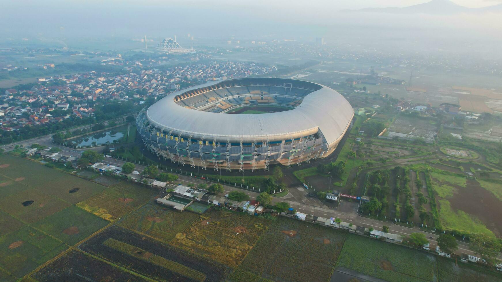 Aerial view of the Beautiful scenery Gelora Bandung Lautan Api Football or Soccer Stadium in the Morning with Blue Sky. Bandung, Indonesia, May 6, 2022 photo
