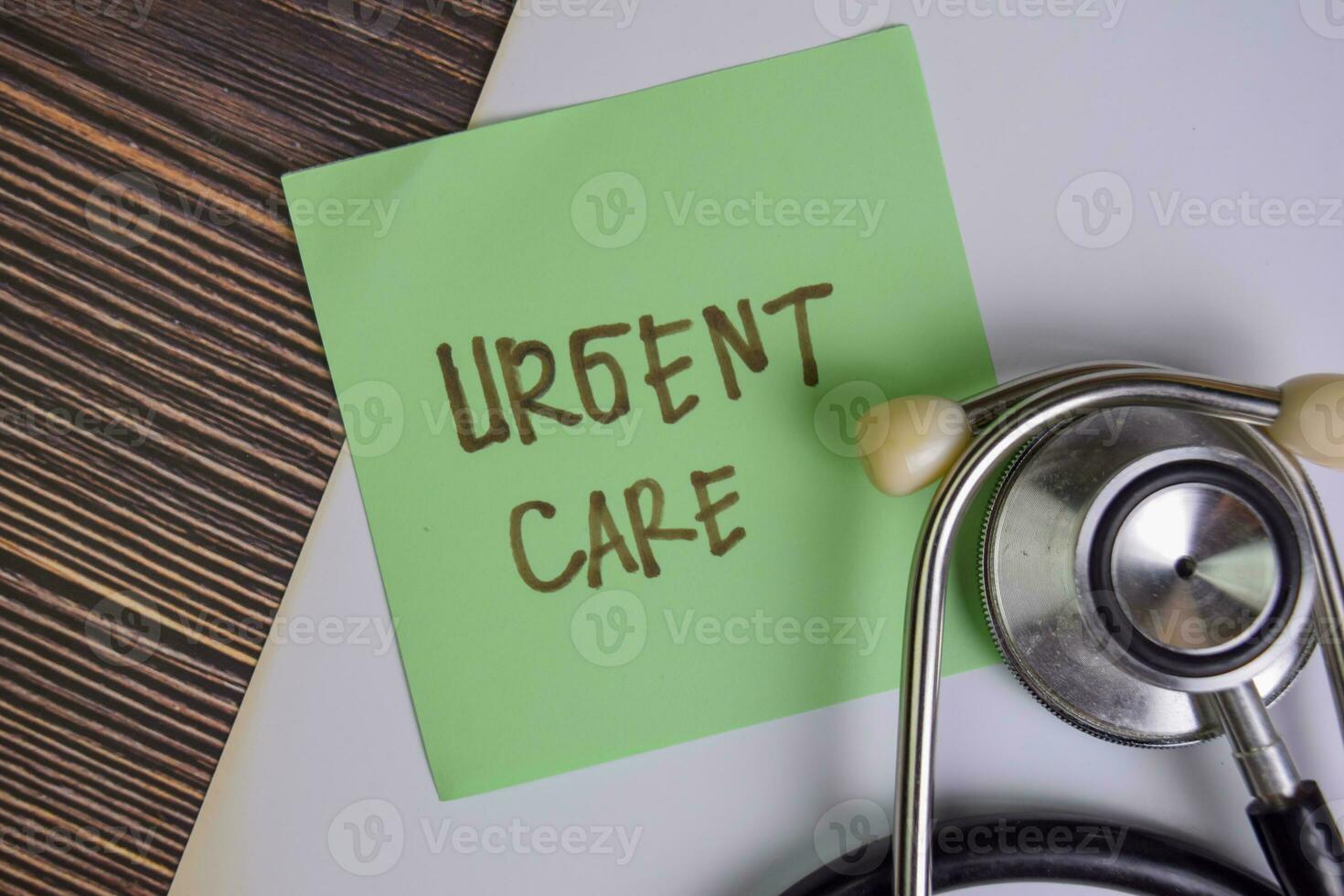 Urgent Care write on sticky notes isolated on Wooden Table. photo