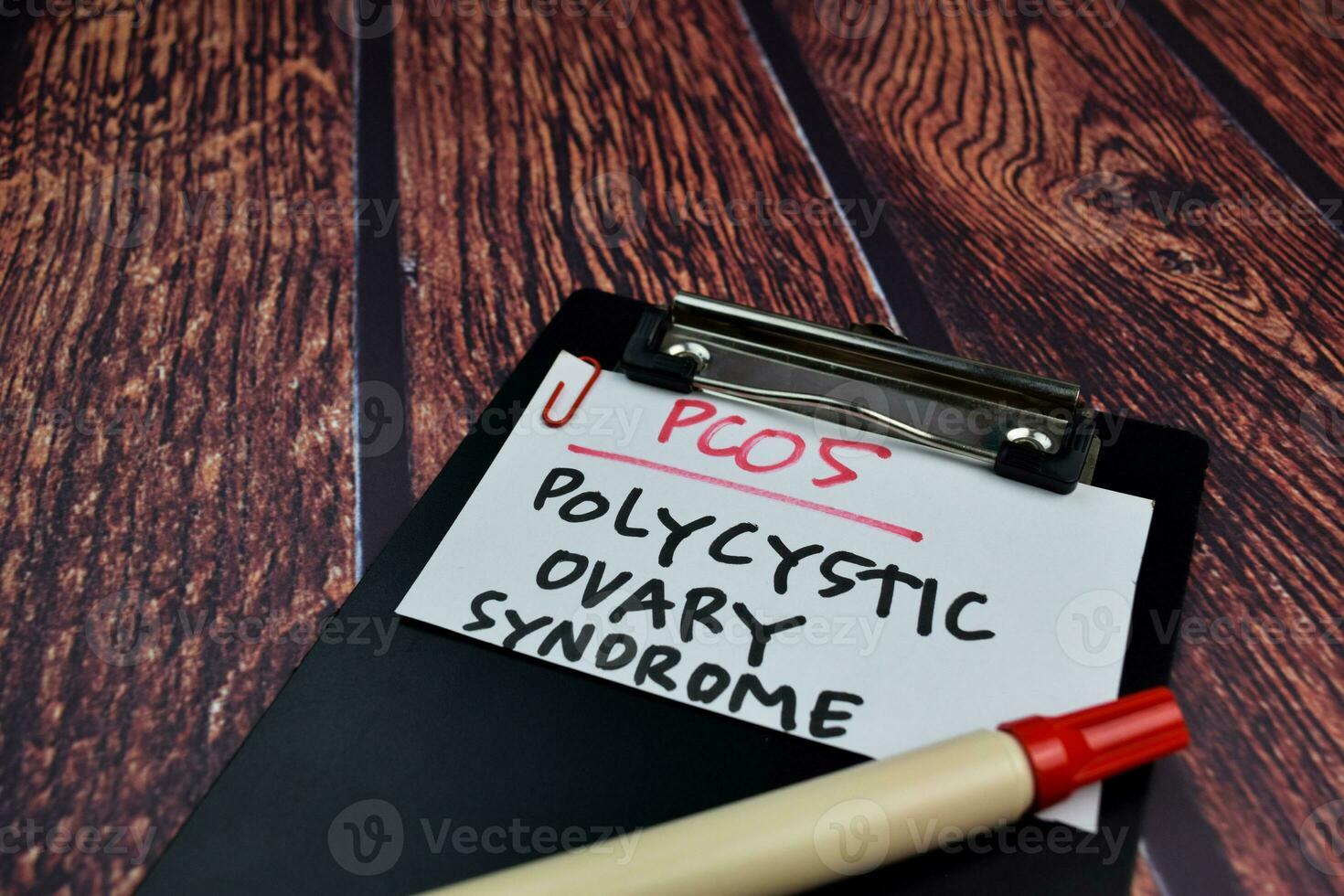 PCOS. Polycystic Ovary Syndrome write on sticky notes. Isolated on wooden table background photo
