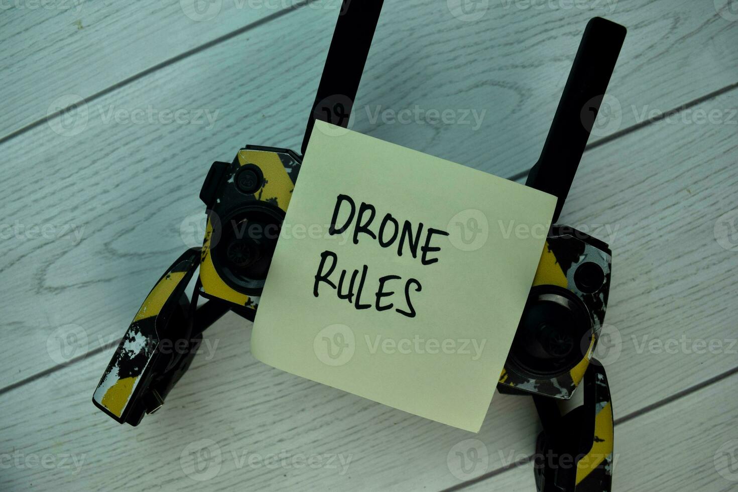 Drone Rules write on sticky notes isolated on Wooden Table. photo