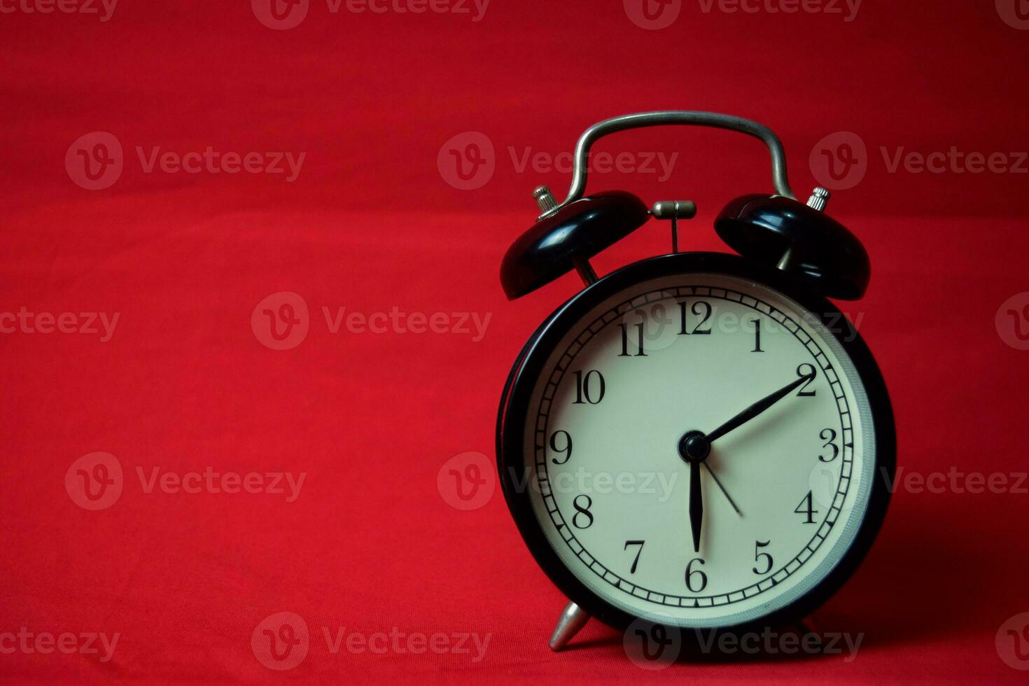 Clock ticking to 6 o'clock on the red background photo