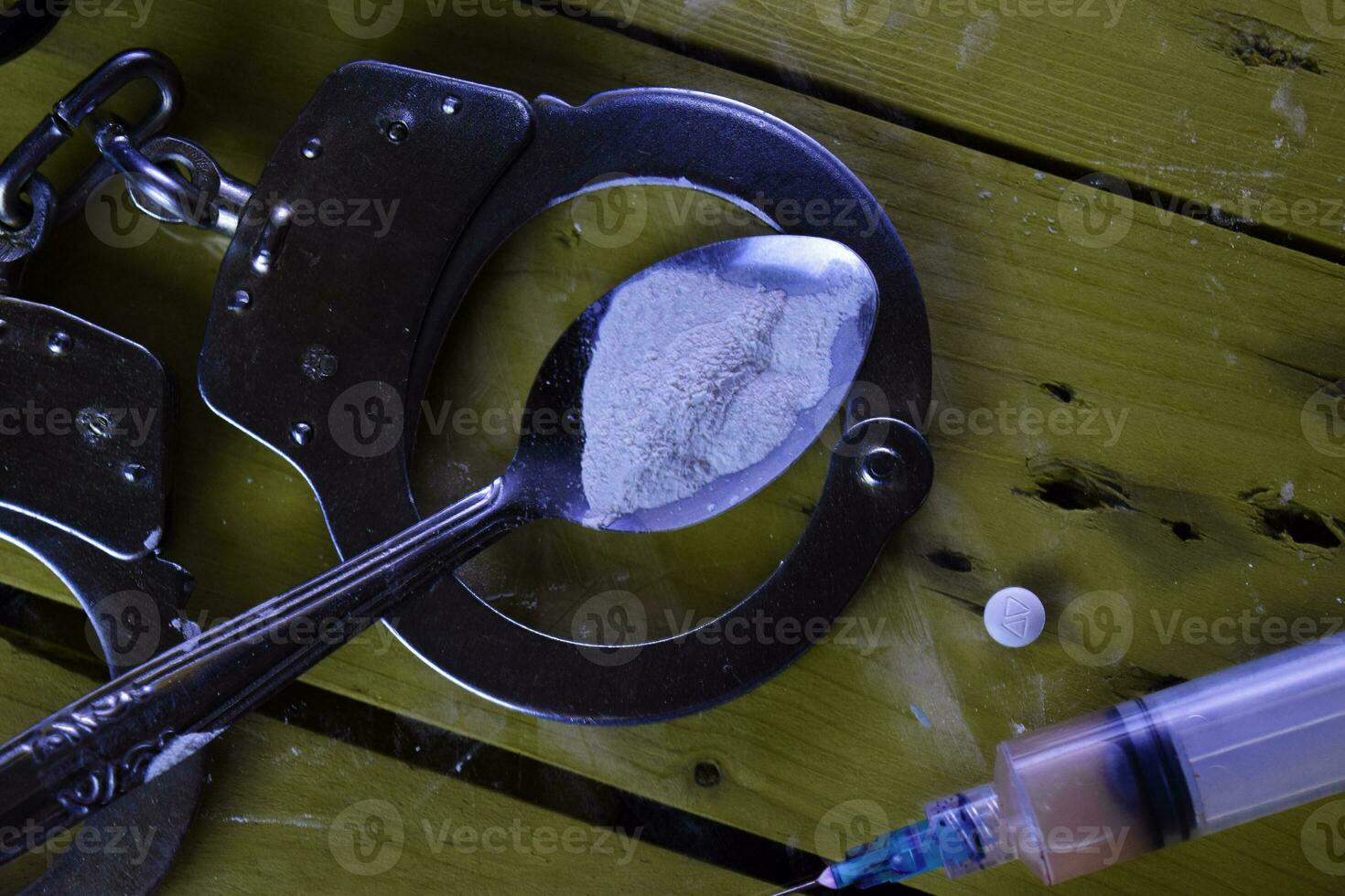 syringe and Indonesia rupiah and Cocaine ready for uses on wooden table. Selective focus on Cocaine. Cocaine Drug Addiction Concept photo